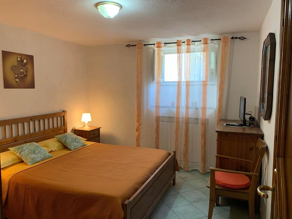 a bedroom with a bed and a window and a chair at Delizioso appartamento Girasole in Ischia