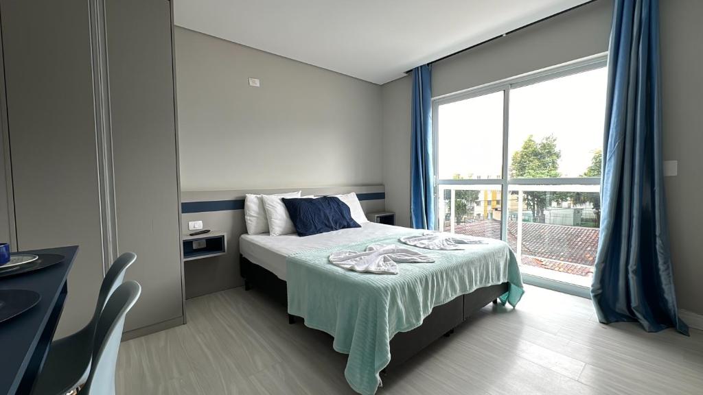 1 dormitorio con cama y ventana grande en 13- Studio Decorado Lindo! Ótimo para Casal!!!, en Curitiba