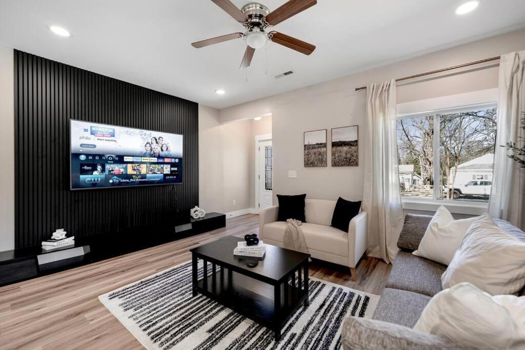 a living room with a couch and a tv at BRAND NEW Cozy Modern Bungalow w/Hot Tub+MovieRoom 7 MIN FROM UPTOWN in Charlotte