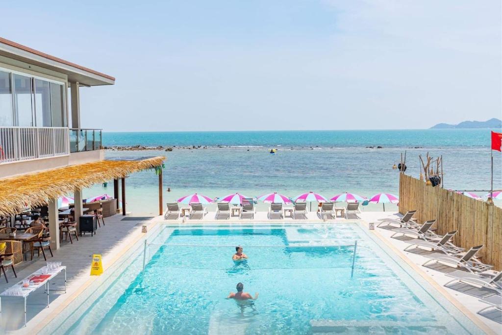 a swimming pool with a view of the ocean at LOVE beach club Koh Samui in Chaweng