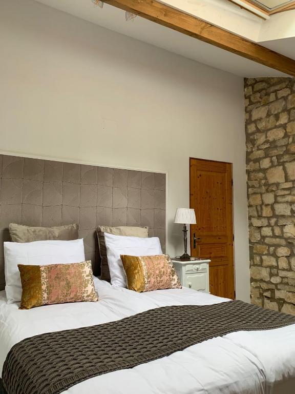 une chambre avec un grand lit blanc avec deux oreillers dans l'établissement Maison Le Haut Fée, à Serécourt