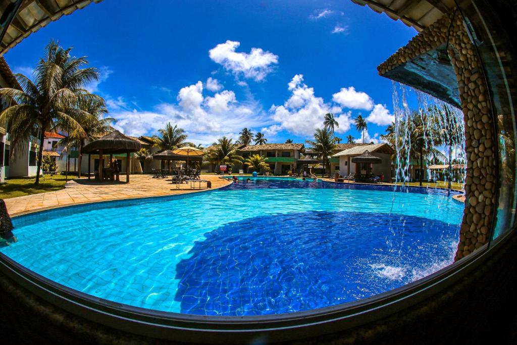 ein großer Pool mit blauem Wasser in einem Resort in der Unterkunft Hotel Real Comandatuba in Ilha de Comandatuba