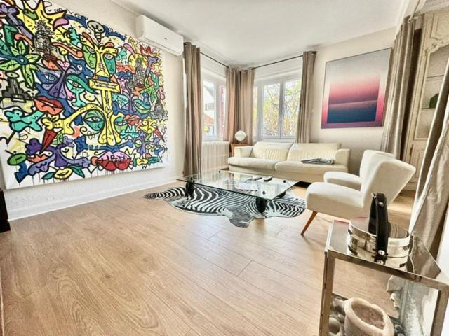 una sala de estar con una gran pintura en la pared en Gîte LE RAPP, en Colmar