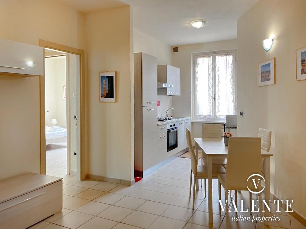 a kitchen with a table and a dining room at Spazioso alloggio con ascensore in Borgo a Buggiano