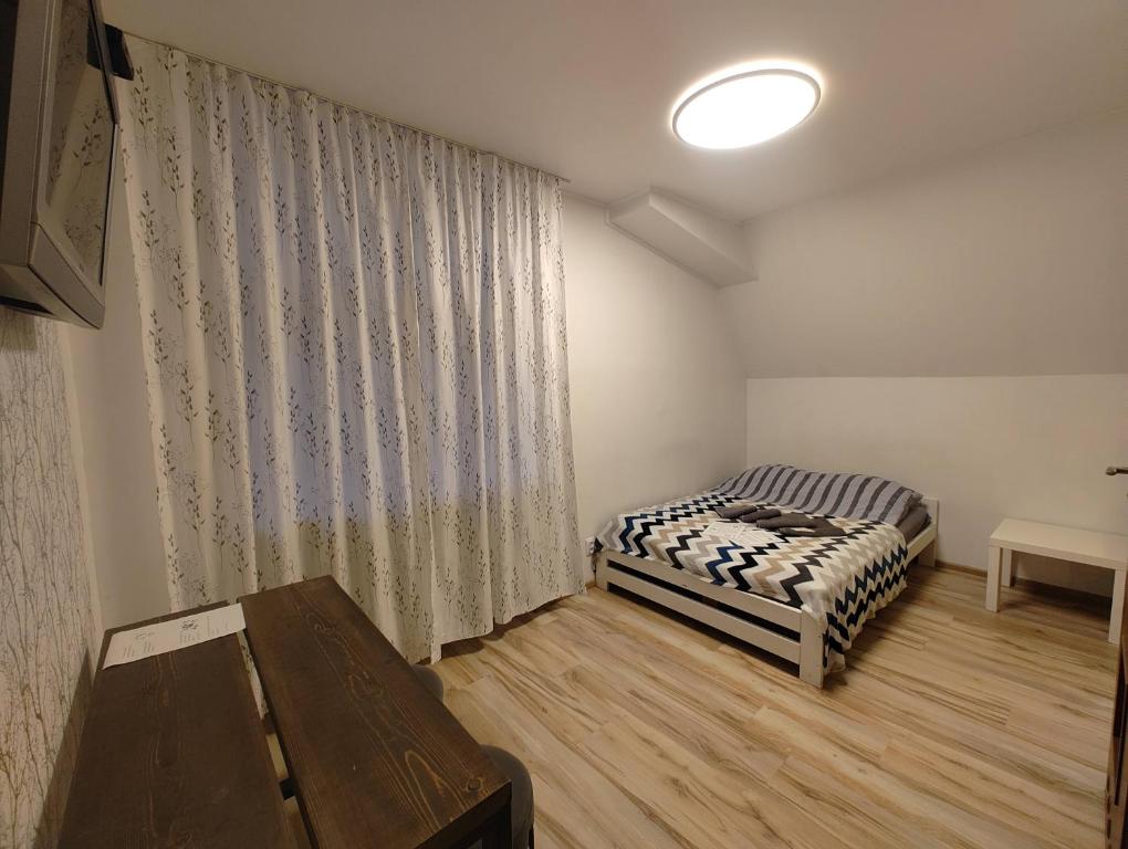 een kleine kamer met 2 bedden en een raam bij FurHouse in Wrocław