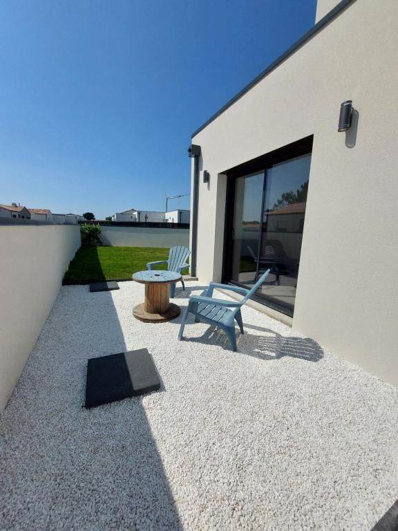 um pátio com um banco e uma mesa ao lado de um edifício em Studio tout confort à 500 m de la mer em Bretignolles-sur-Mer