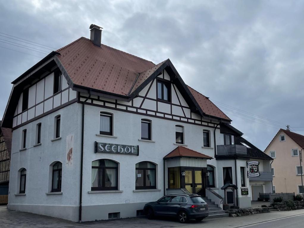 un gran edificio blanco con techo marrón en Gasthof Seehof, en Illmensee