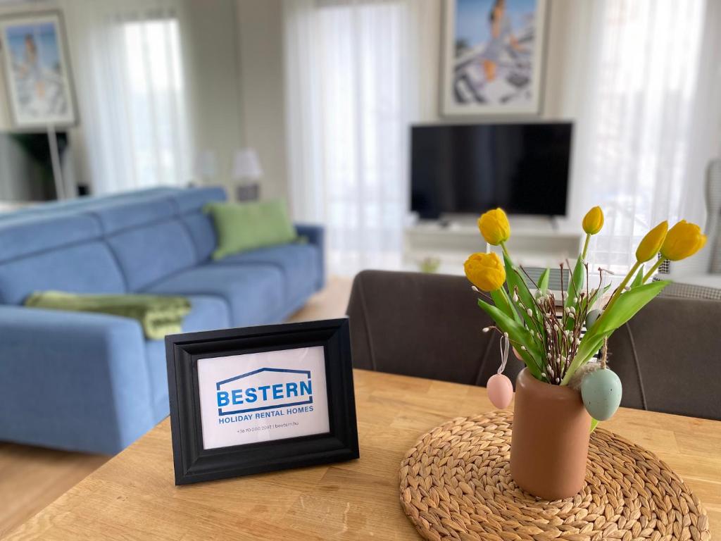 a picture frame and a vase with flowers on a table at Nature in the City upper storey Bestern in Szeged