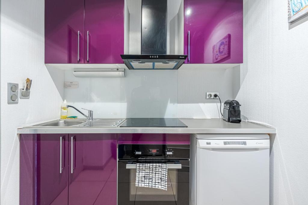a kitchen with purple cabinets and a sink at Les Cabanons de Fonfon in Marseille