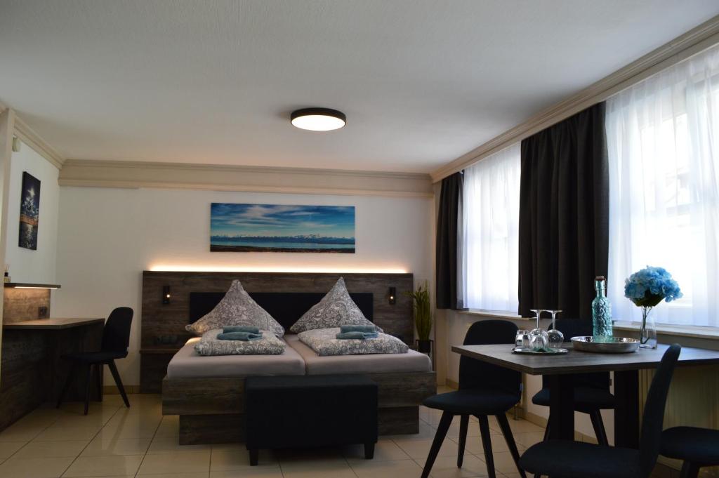 a bedroom with a bed and a table and chairs at Hotel Zum Bengel in Meersburg