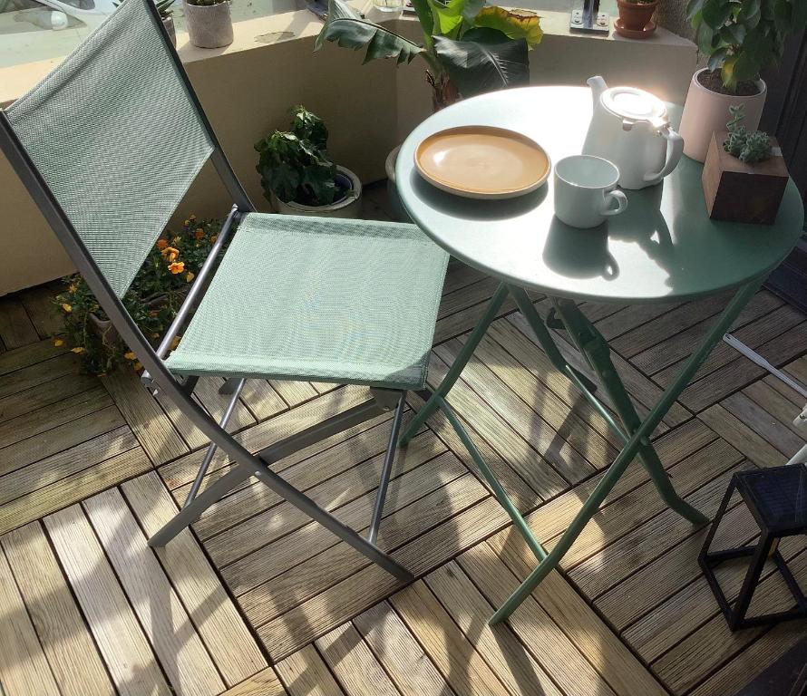 biały stół i krzesło z filiżanką i talerzem w obiekcie Appartement cosy la trinité sur mer w mieście Trinité-sur-Mer
