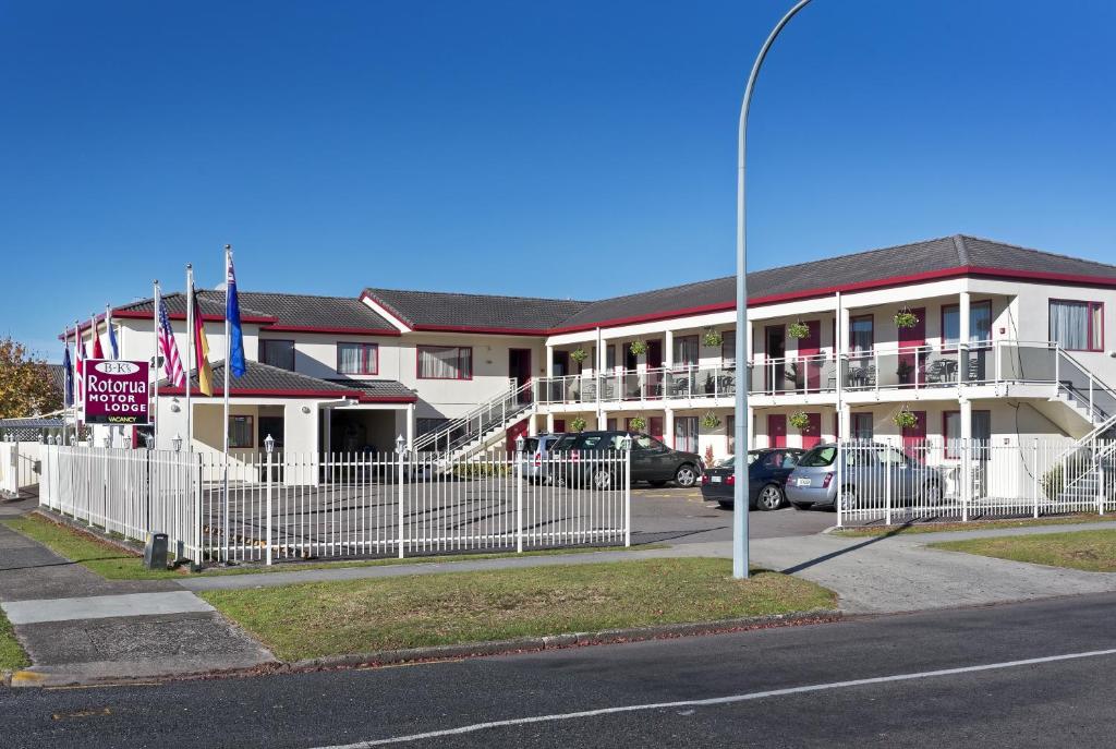 un edificio blanco con coches estacionados frente a él en BK's Rotorua Motor Lodge en Rotorua
