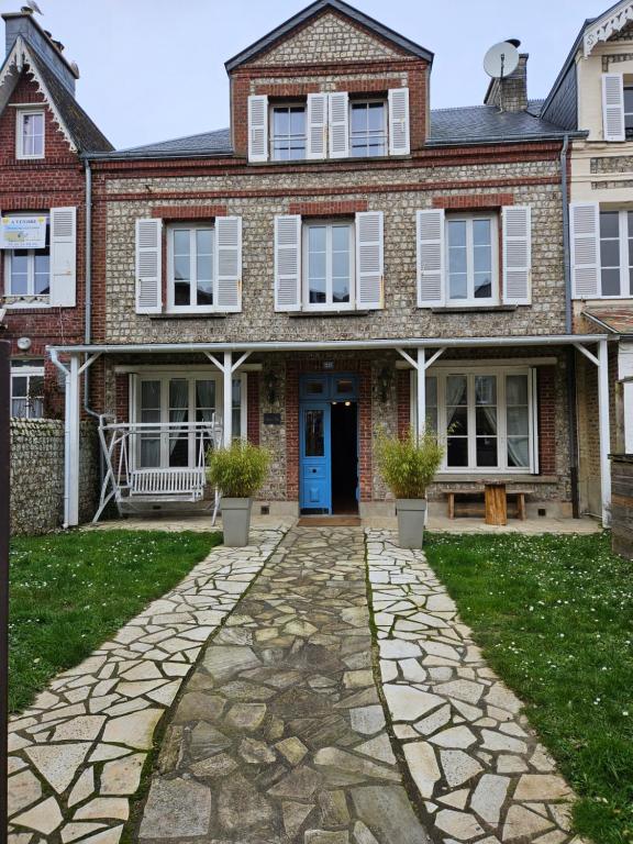 a brick house with a cobblestone driveway at Soleil du Matin in Étretat