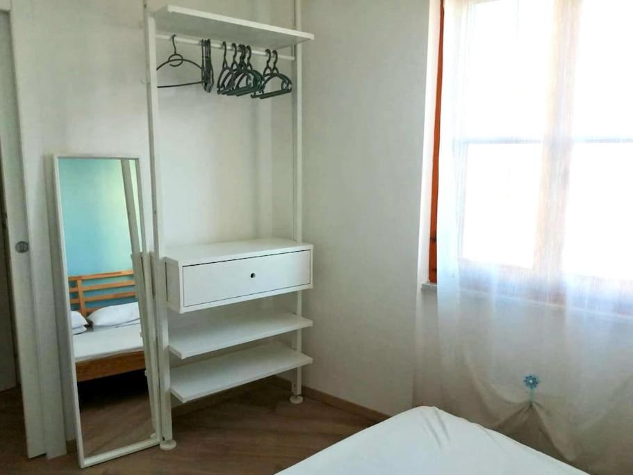 a white cabinet with a mirror in a bedroom at CLhome: 3 minuti dal mare in Alghero