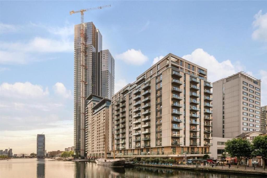 a group of tall buildings next to a river at Luxury Penthouse 2 bedrooms flat in Canary Wharf in London