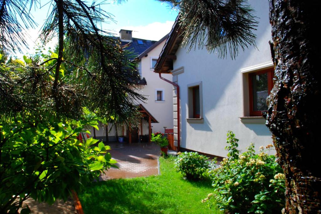 a white house with a tree in the yard at Hortensja in Iława