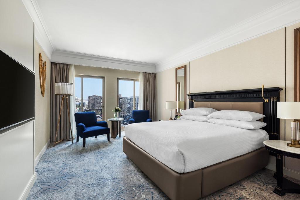 a hotel room with a bed and a desk and chairs at Intercontinental Cairo Citystars by IHG in Cairo
