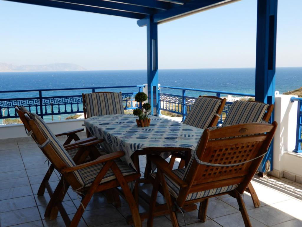 una mesa y sillas en un balcón con vistas al océano en Απεραντο Γαλαζιο, en Agia Pelagia - Citera