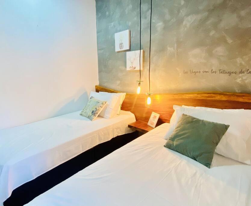 モンポスにあるCómodo Apartamento céntricoのベッド2台が備わる客室で、壁には絵画が飾られています。