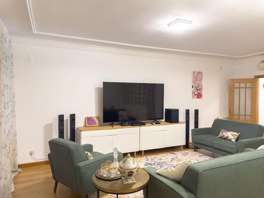 uma sala de estar com 2 sofás e uma televisão de ecrã plano em apartamento grande da Gama em Lisboa