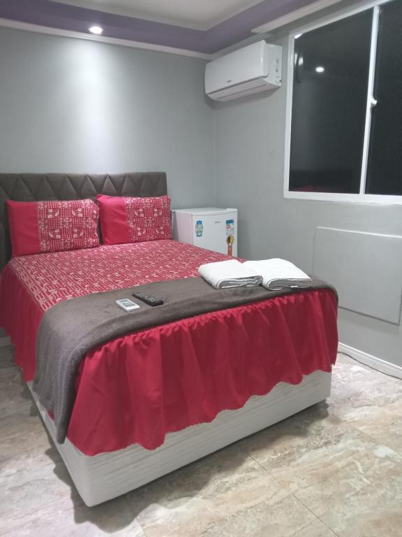 a bedroom with a bed with red pillows and a window at São Salvador Guest House in Salvador