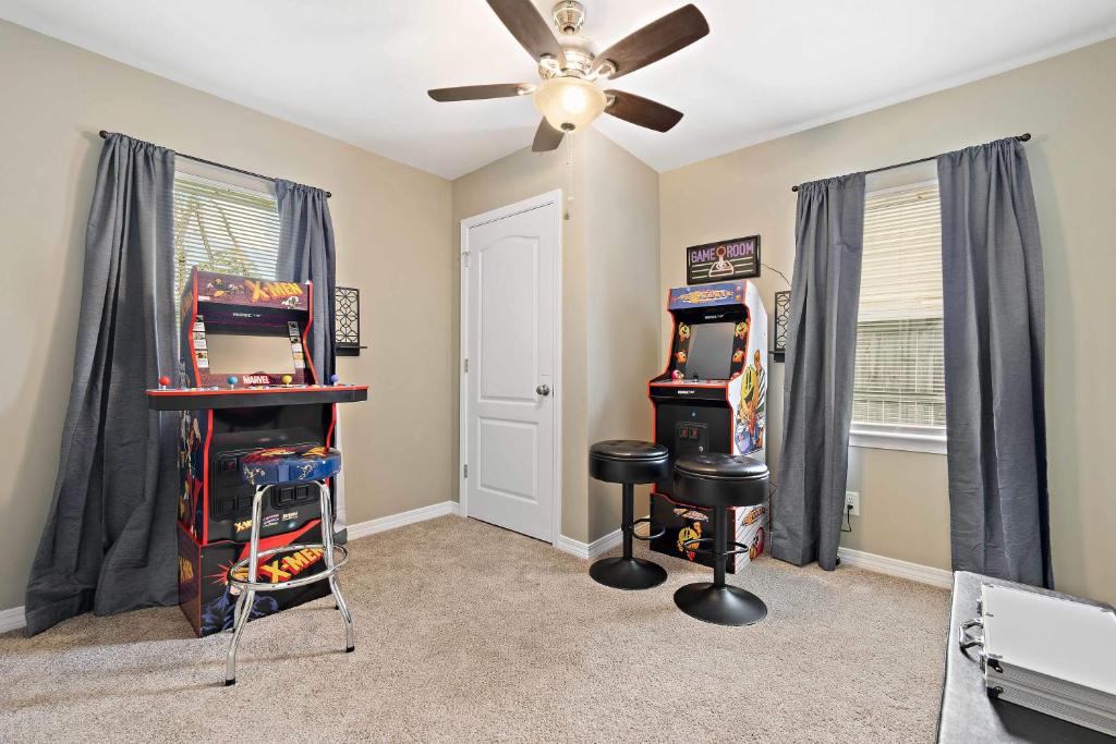 Habitación con 2 juegos de arcade y ventilador de techo. en Renovated Home Perfect for Family, en Mobile