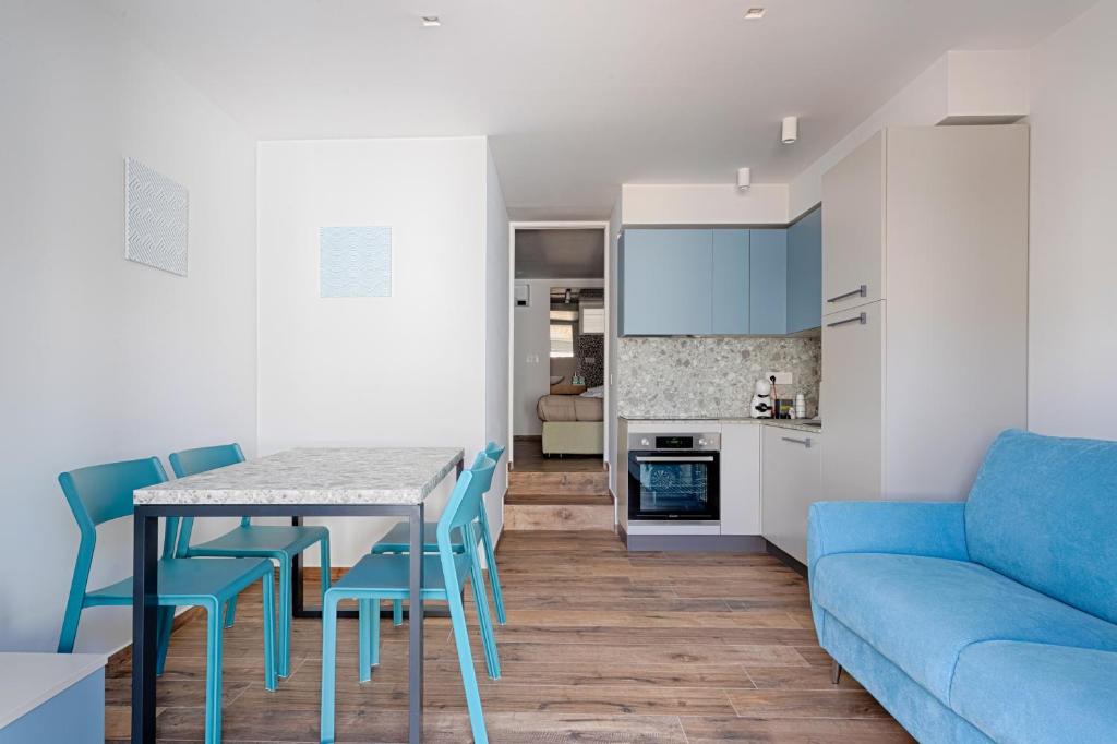 ein Wohnzimmer mit einem blauen Sofa, einem Tisch und Stühlen in der Unterkunft Palazzo Cajeta in Gaeta