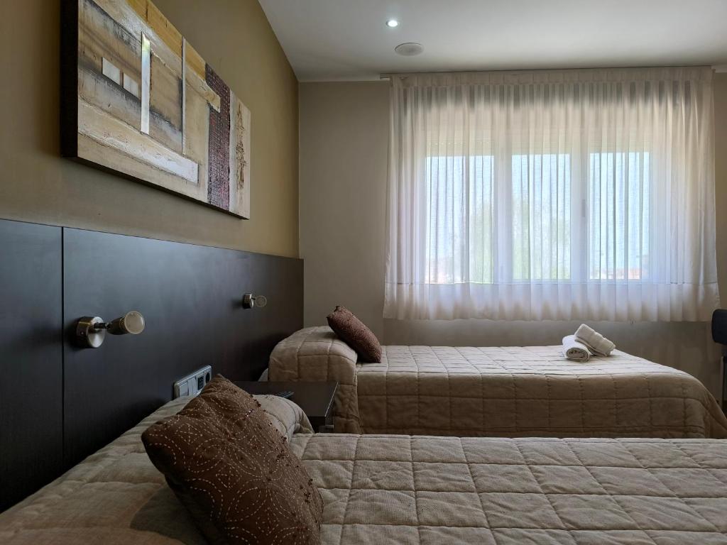 Habitación de hotel con 2 camas y ventana en Hotel Santa Barbara, en Andorra