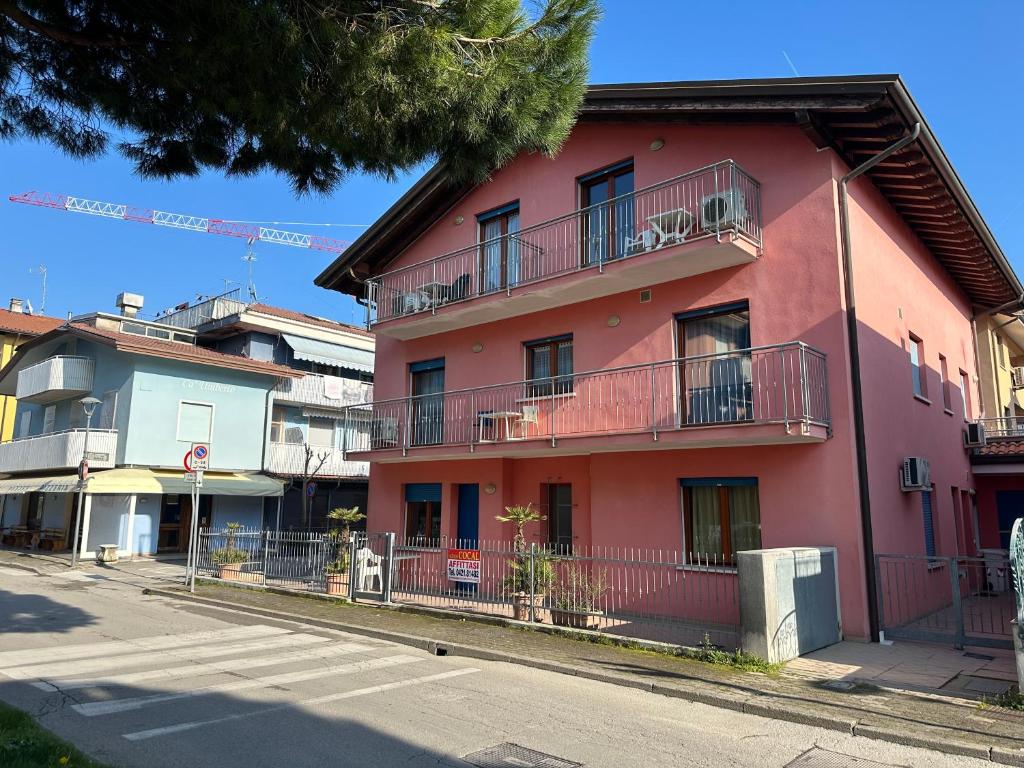 a pink building on the side of a street at Residence Guardamar - Agenzia Cocal in Caorle