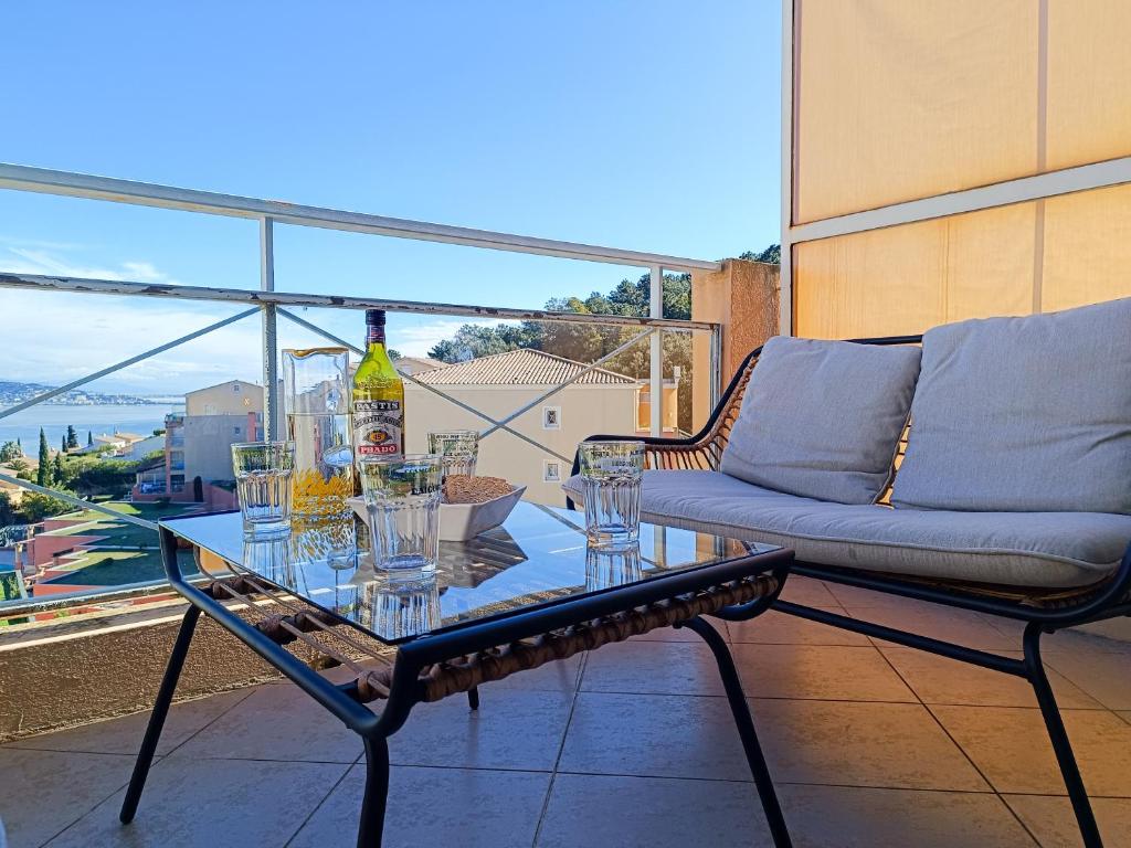 - une table avec une bouteille de vin et des verres sur un balcon dans l'établissement Spacieux 3P Mer & Montagne - Les Clés de l Estérel, à Théoule-sur-Mer