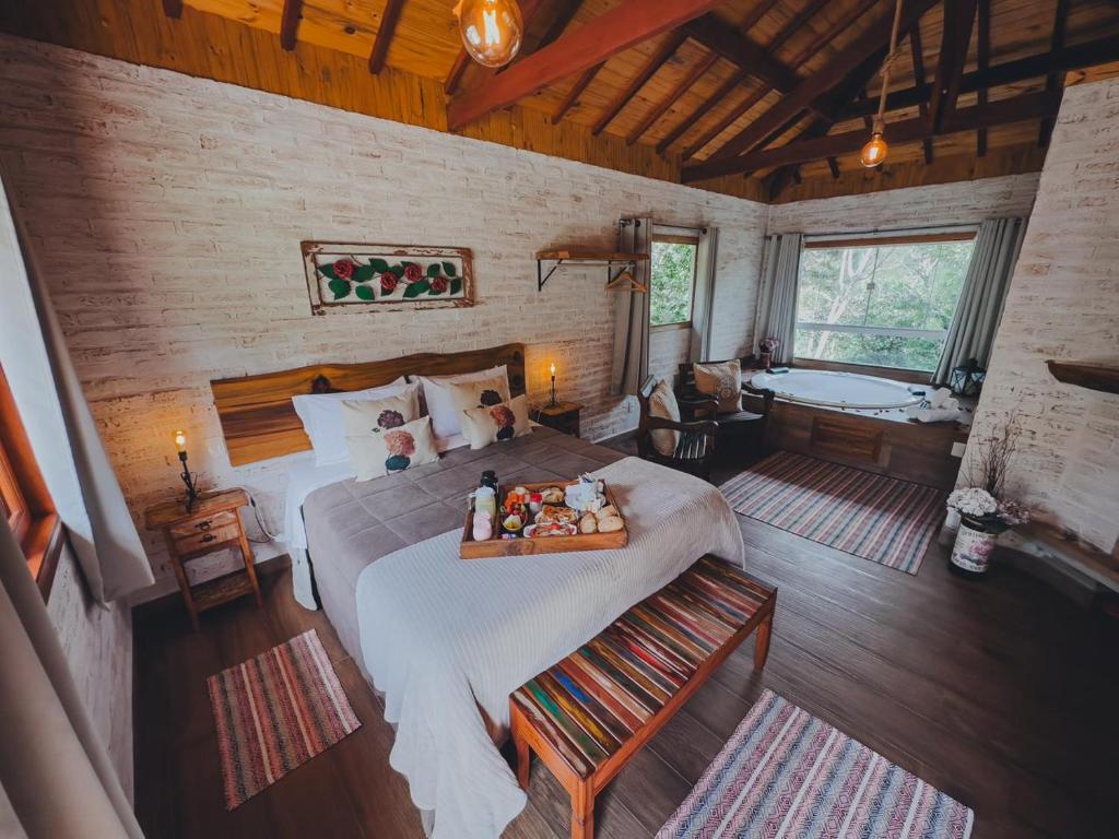 um quarto com uma cama e uma banheira num quarto em Residencial Vilas Boas MV em Monte Verde