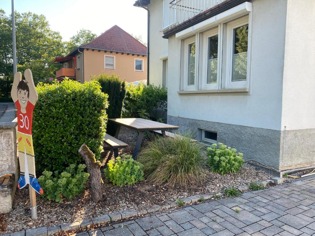 un jardín con un banco frente a una casa en Ferienwohnung Todzi, en Dudenhofen