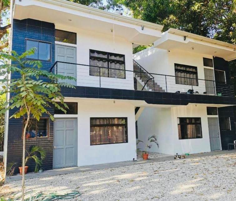 Cette maison blanche dispose d'une terrasse couverte et d'un balcon. dans l'établissement Apartamentos Tamarindo Guanacaste 3, à Guanacaste