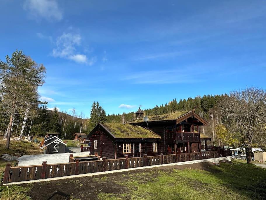 Eidsvollhytta- et unikt sted for unike opplevelser في Eidsvoll: منزل خشبي كبير مع سقف من العشب