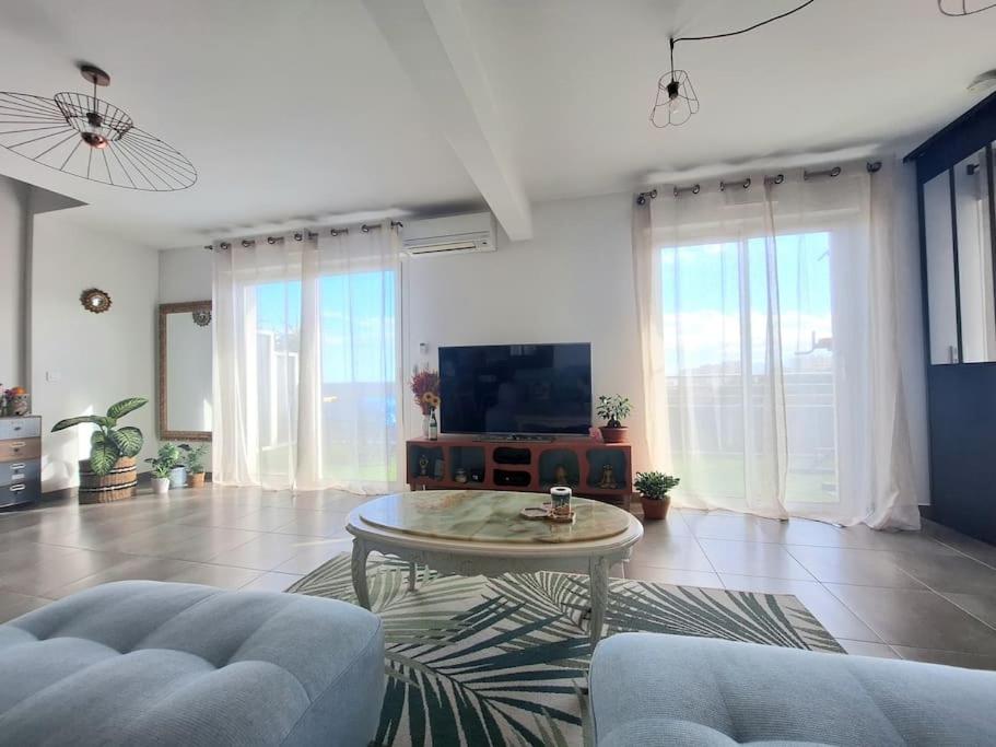 un salon avec un canapé, une table et une télévision dans l'établissement Appartement 3 pièces vue mer, à Bastia