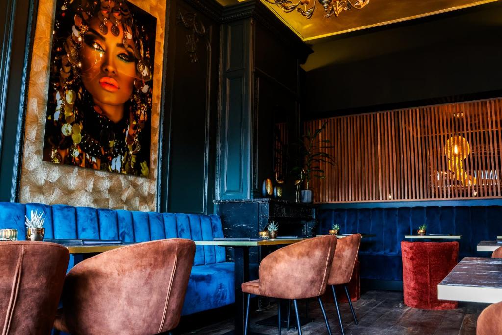 comedor con sofá azul, mesa y sillas en Hotel XL, en Zandvoort
