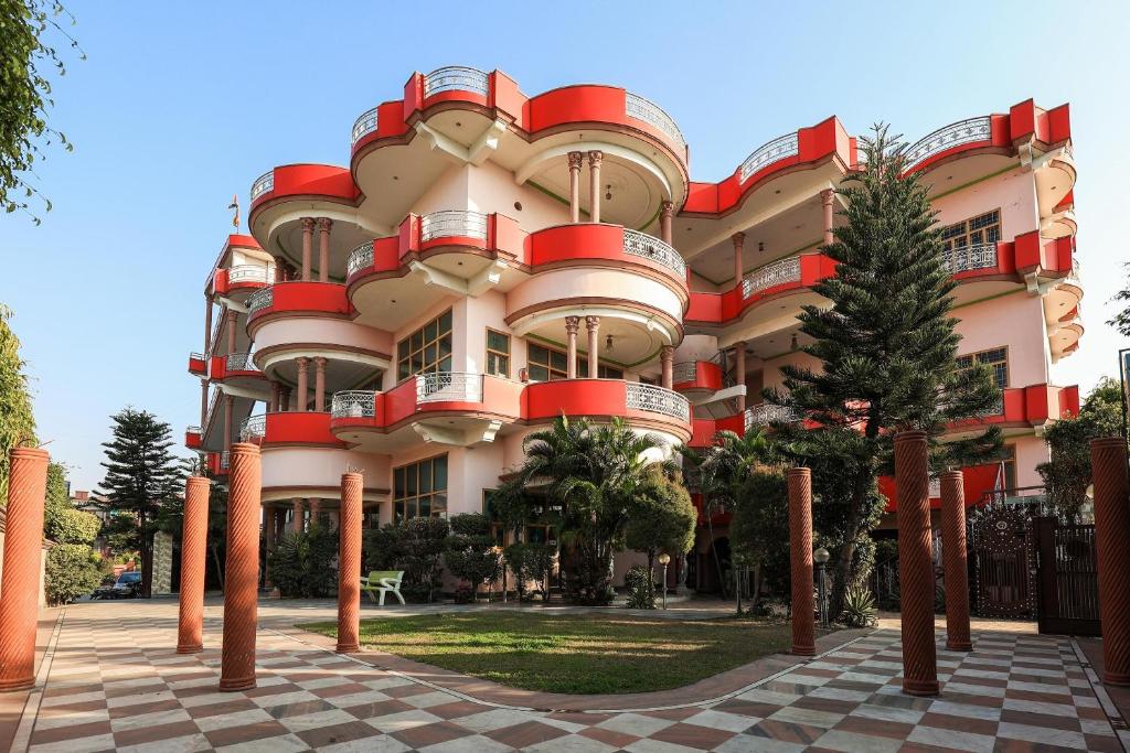 ein Gebäude mit roten Balkonen an der Seite in der Unterkunft OYO Flagship 86687 Hotel Anandlok in Haldwani-Kathgodam