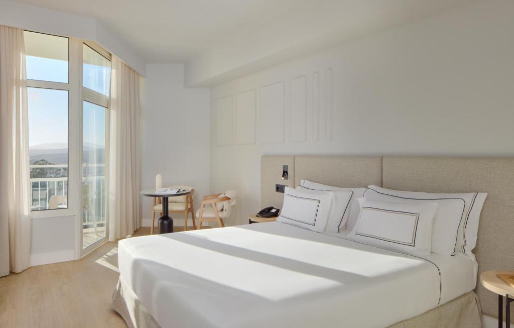 a bedroom with a large white bed and a window at Meliá Lloret de Mar in Lloret de Mar