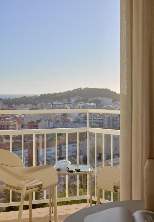 a balcony with chairs and a view of a city at Meliá Lloret de Mar in Lloret de Mar