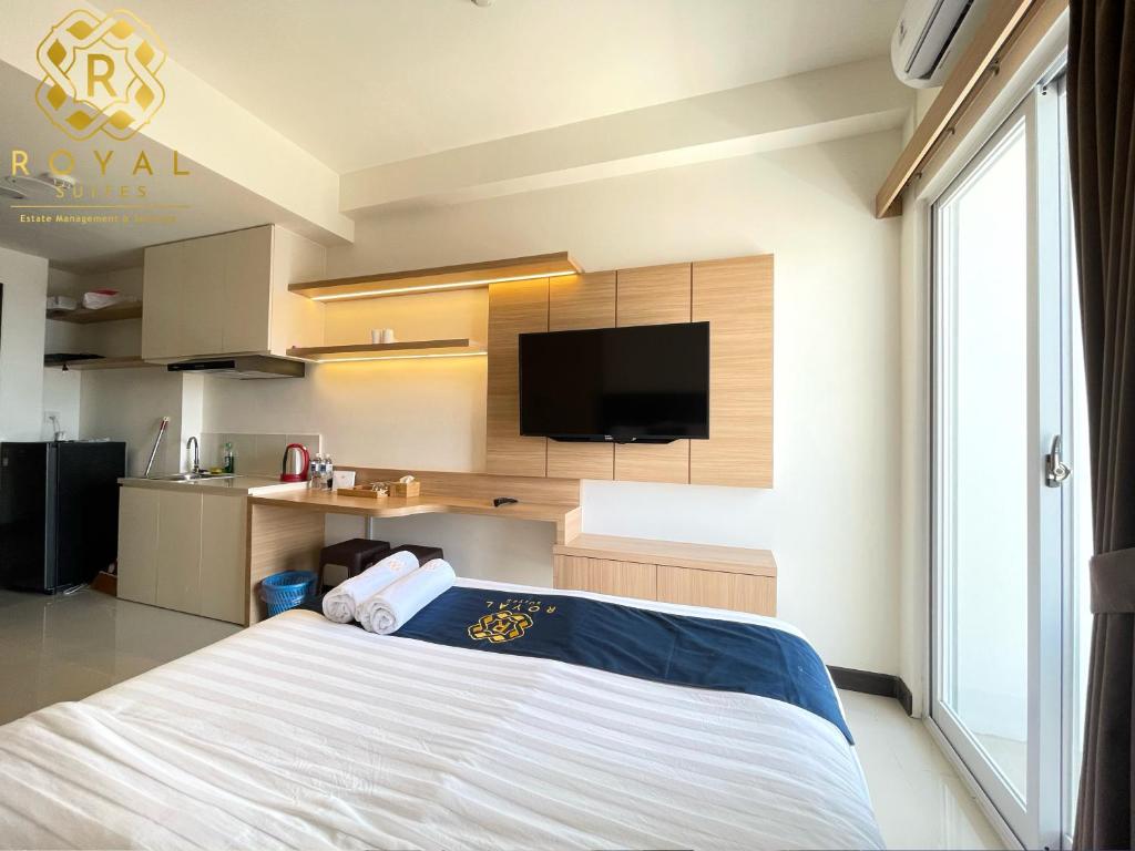 een slaapkamer met een bed en een flatscreen-tv bij Royal Suites Studio 17th Floor - Citra Plaza Nagoya Apartment in Jodoh