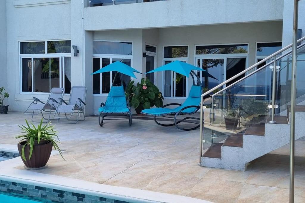 um pátio com cadeiras azuis e uma piscina em Crystal Resort em St Mary