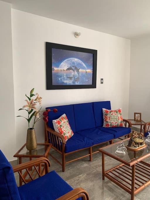 sala de estar con sofá azul y mesa en Apartamento en Pisco, en Pisco