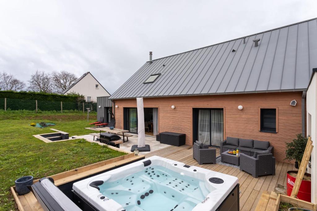 een hot tub op een terras naast een huis bij La perle de mer - Charmante maison avec jacuzzi in Erquy