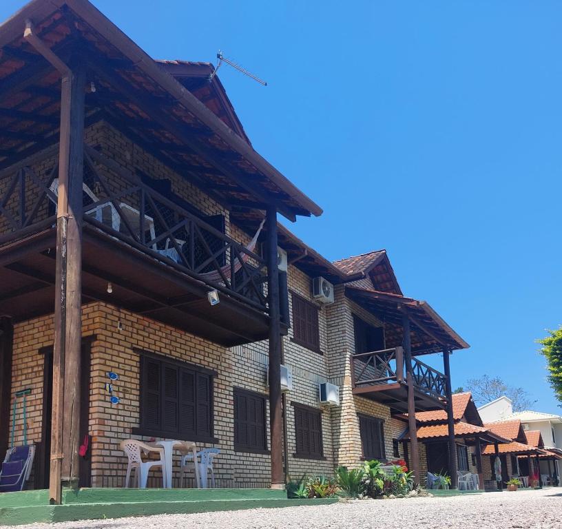a building with a balcony with a table and chairs at Pousada Canto das Trilhas in Bombinhas
