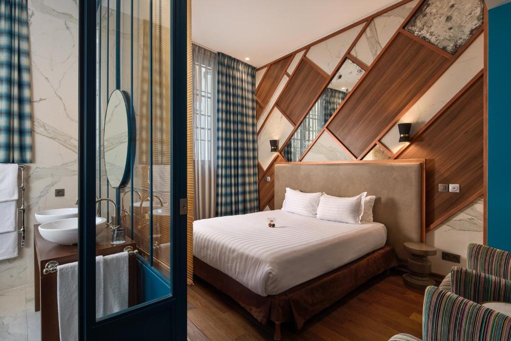 - une chambre avec un lit et une salle de bains pourvue d'un lavabo dans l'établissement Le Robinet d'Or, à Paris