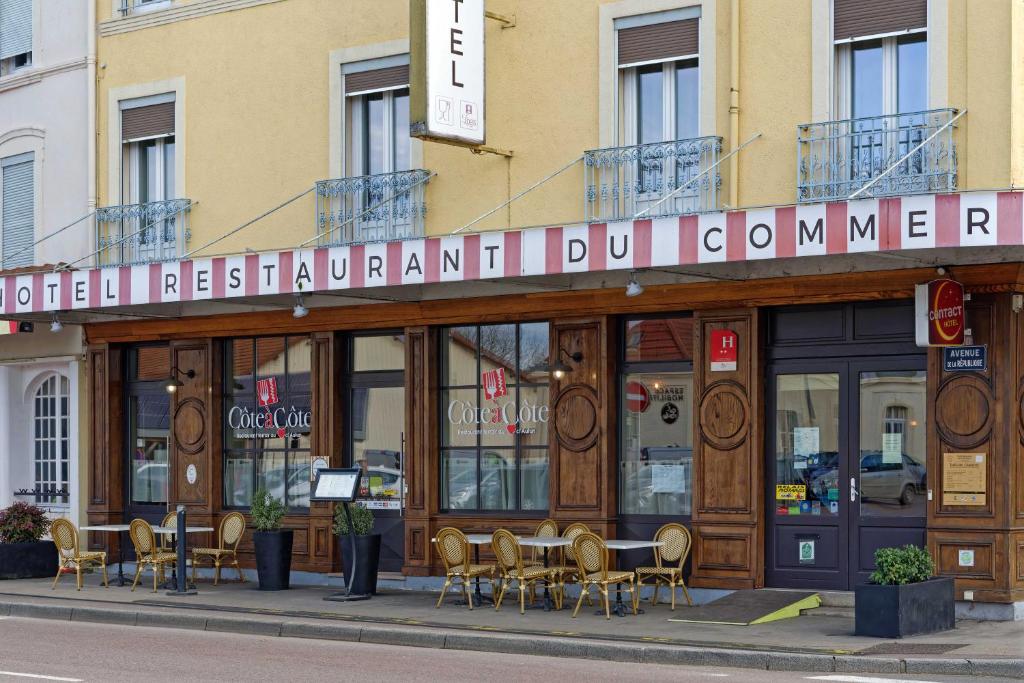 a restaurant with tables and chairs in front of a building at Contact Hôtel du Commerce et son restaurant Côte à Côte in Autun