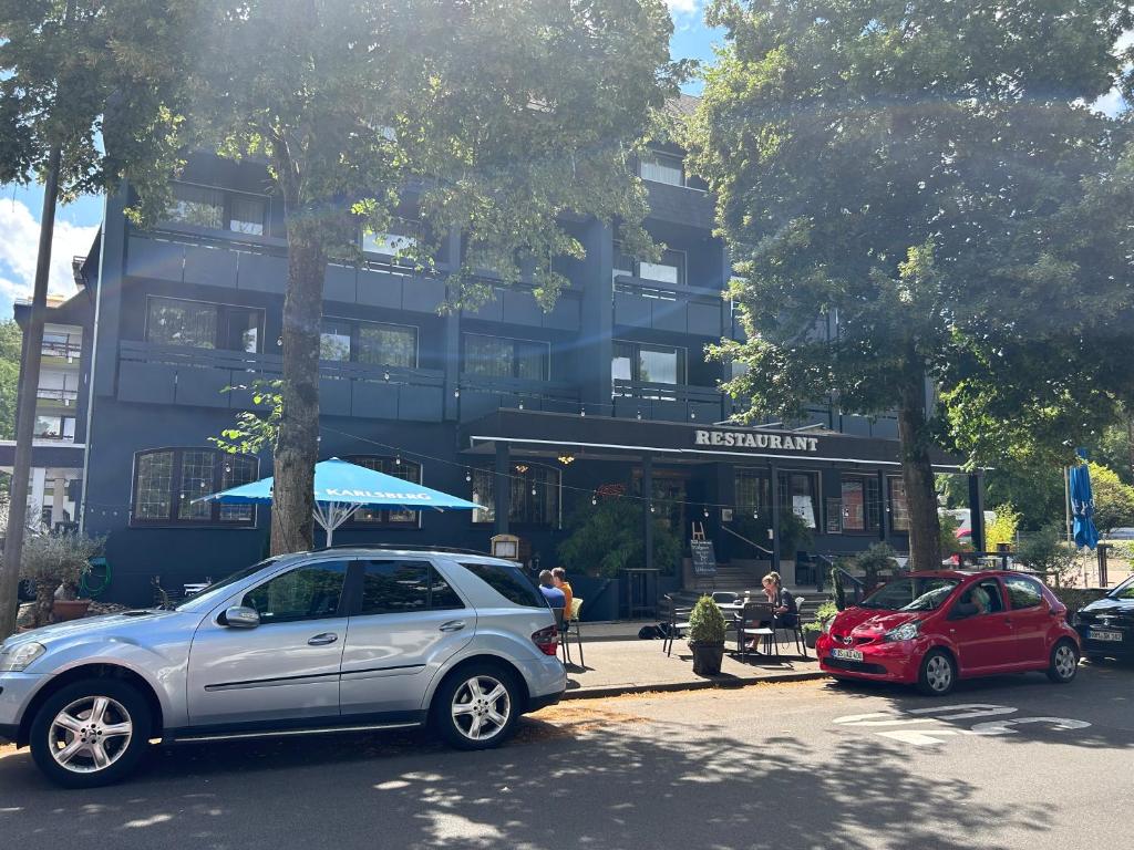 zwei Autos, die auf einer Straße vor einem Gebäude geparkt sind in der Unterkunft Hotel Stadt Homburg in Homburg