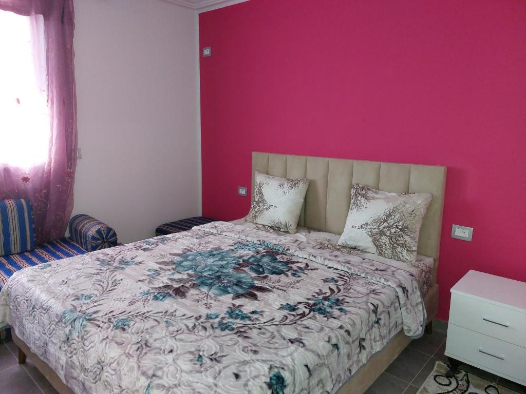 1 dormitorio con 1 cama con pared de color rosa en Dar Zaineb, en Túnez