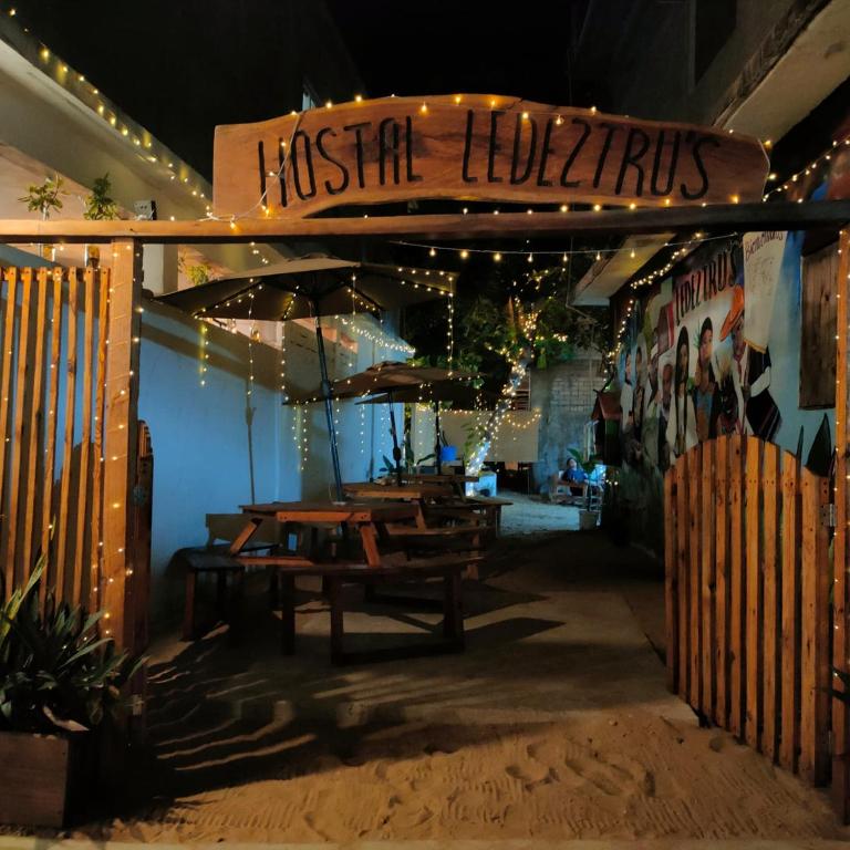 a restaurant with a sign that reads justitzitz tables at Hostal Ledeztrus in Zipolite
