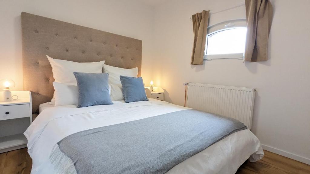 a bedroom with a large white bed with blue pillows at FeWo Catalina in Westerstede